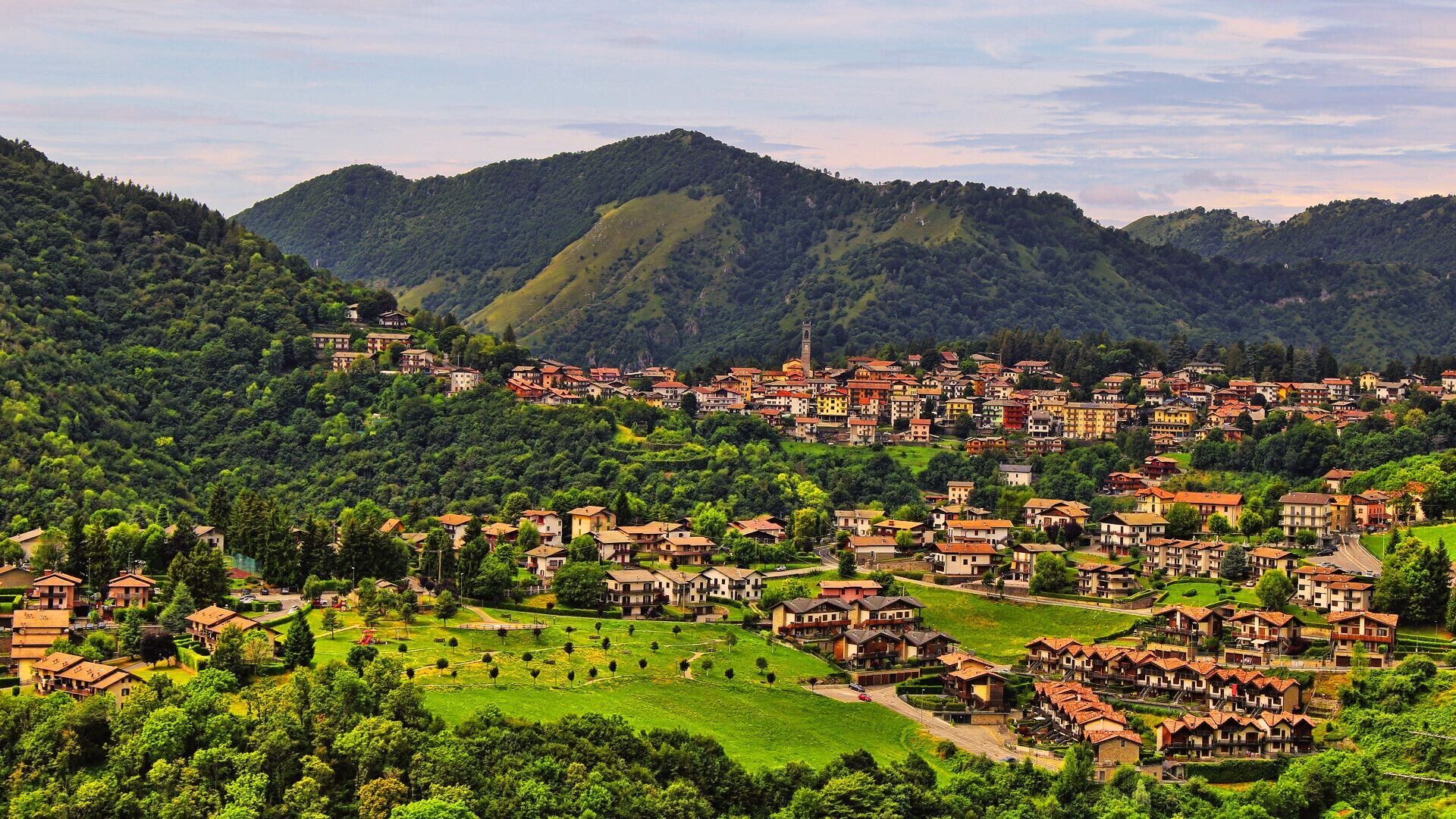 A hillside village with traditional architecture, terraced houses, and a prominent church tower.