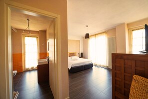Una habitación de hotel con cama, baño y escritorio de madera.