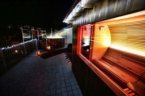 A corridor with a wooden bench, a hot tub, and a railing with lights. - T'AMI Hotel Resort SPA (Selvino)