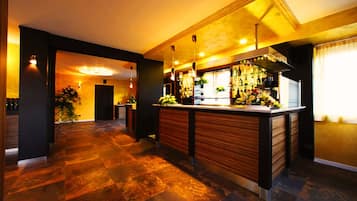 Un área de bar moderna con una barra de madera, iluminación ambiental y piso a cuadros.
