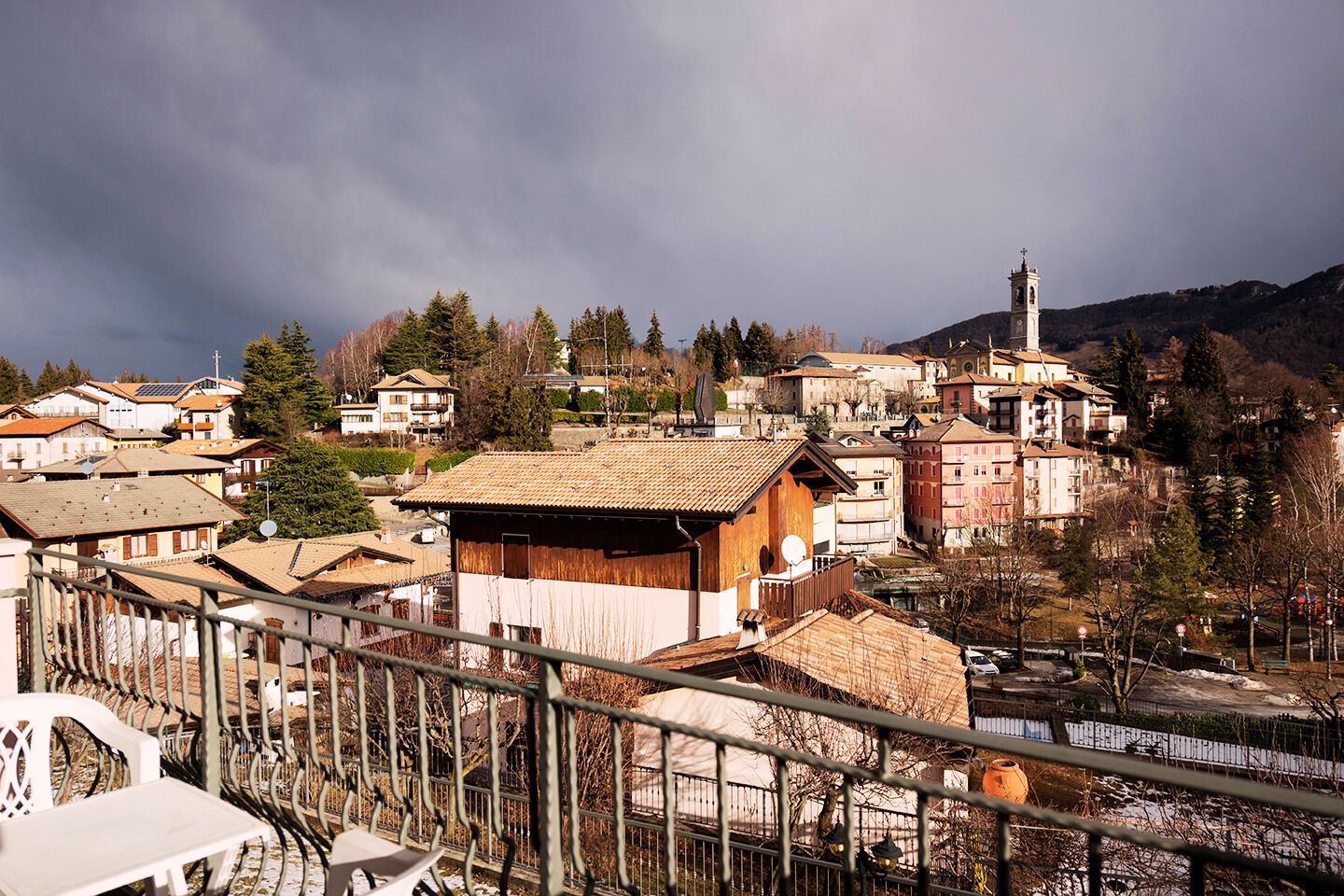 A mountainous village with traditional buildings, a church, and a view of the surrounding landscape.