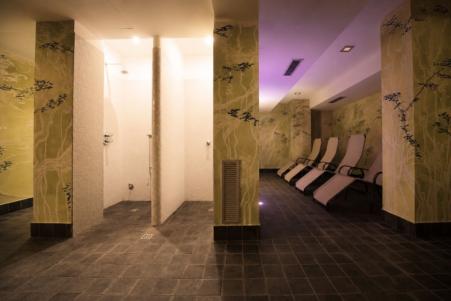 A hallway with a shower area and a seating area with chairs.