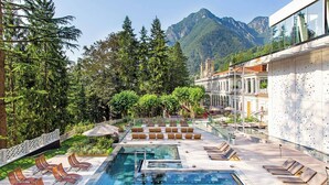 A rooftop pool area with lounge chairs, a glass balustrade, and a mountainous backdrop. - T'AMI Hotel Resort SPA (Selvino)