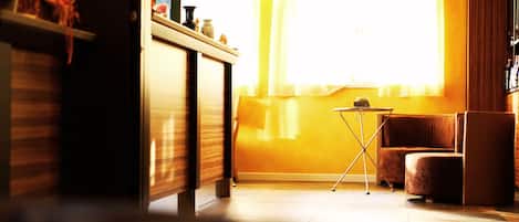 A room with a sofa, a small table, and a window with curtains.