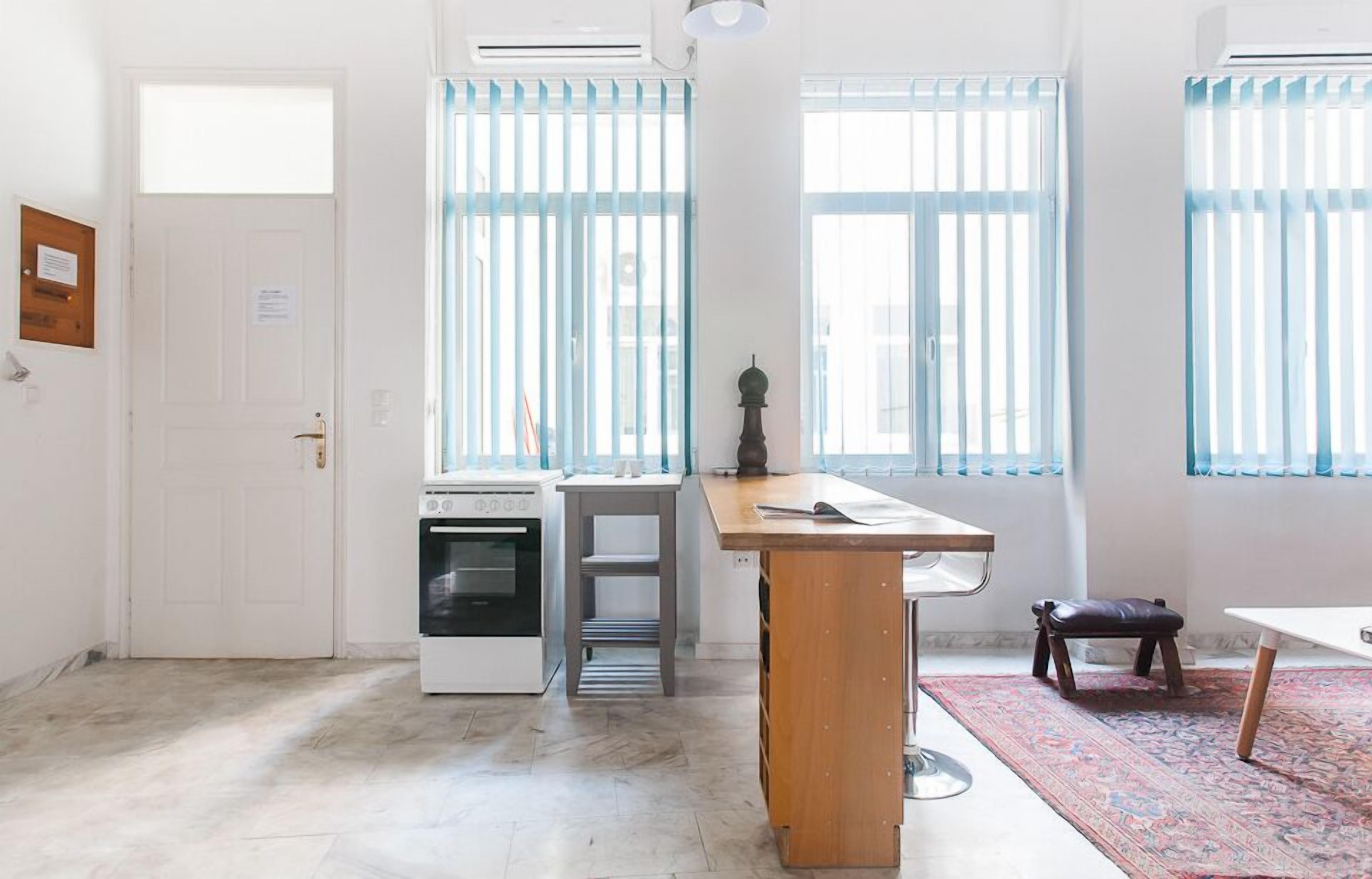A kitchen with a built-in oven, a wooden table, and a bench.