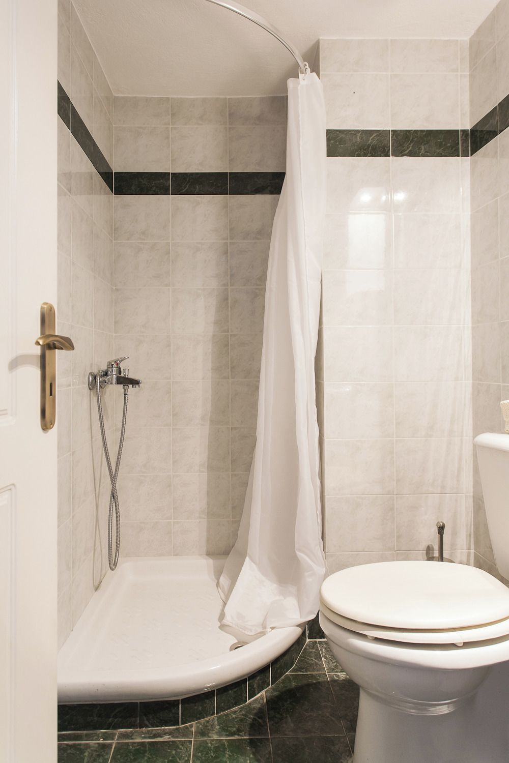 Une salle de bain avec douche, toilettes et baignoire.