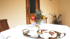 A dining table with a fruit bowl, white cups, and pastries. - Villa Vlatos (Kissamos)