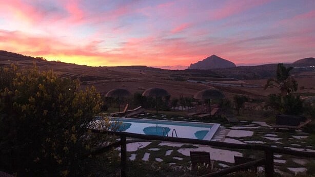 Ein Poolbereich mit Blick auf sanfte Hügel und ein Berg in der Ferne.