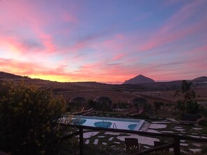 A pool area with a view of rolling hills and a mountain in the distance. - B&B Baglio degli Ulivi (Valderice)
