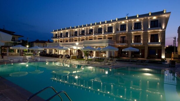 A hotel with a swimming pool, outdoor seating, and a well-lit facade. - Danai Hotel & Spa (Katerini)