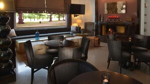 A cozy lounge area with comfortable seating, a fireplace, and a television. - Danai Hotel & Spa (Katerini)