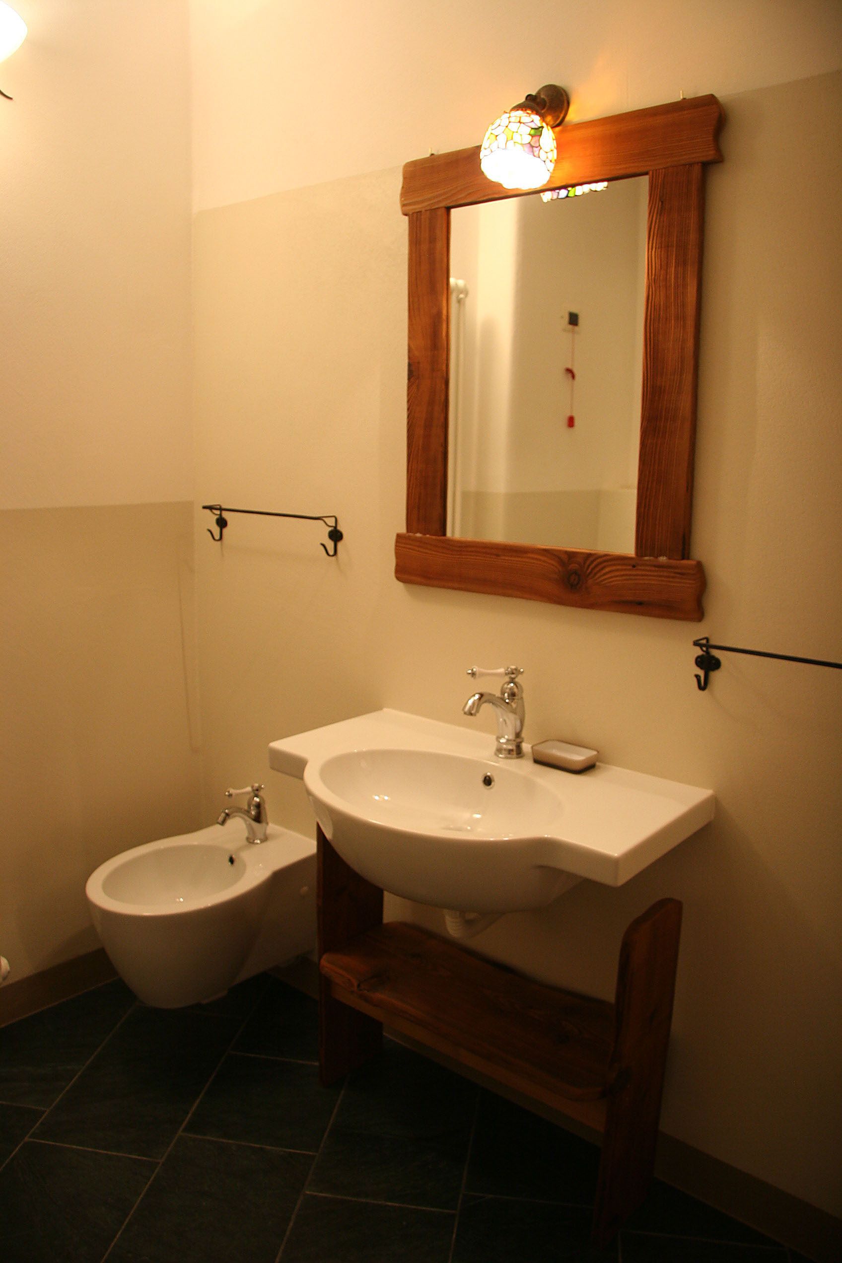 A bathroom with a white sink, a mirror, and a bidet.