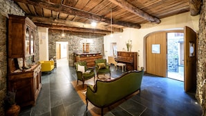 Un interior rústico con paredes de piedra, muebles de madera y un piano.