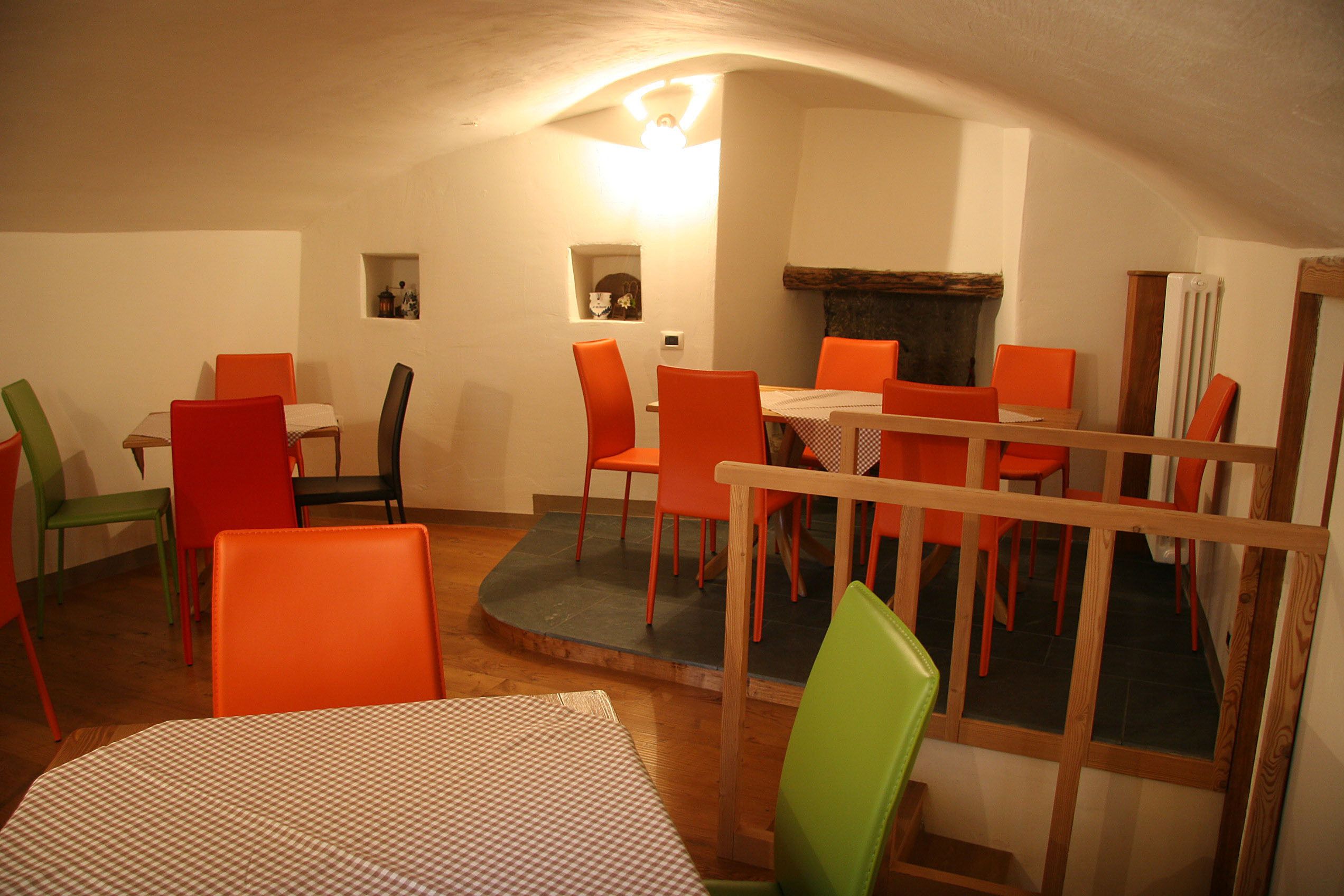 Un comedor con una mesa redonda y varias sillas color naranja.