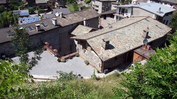 Un barrio residencial con edificios de piedra, un patio empedrado y paneles solares en los tejados.