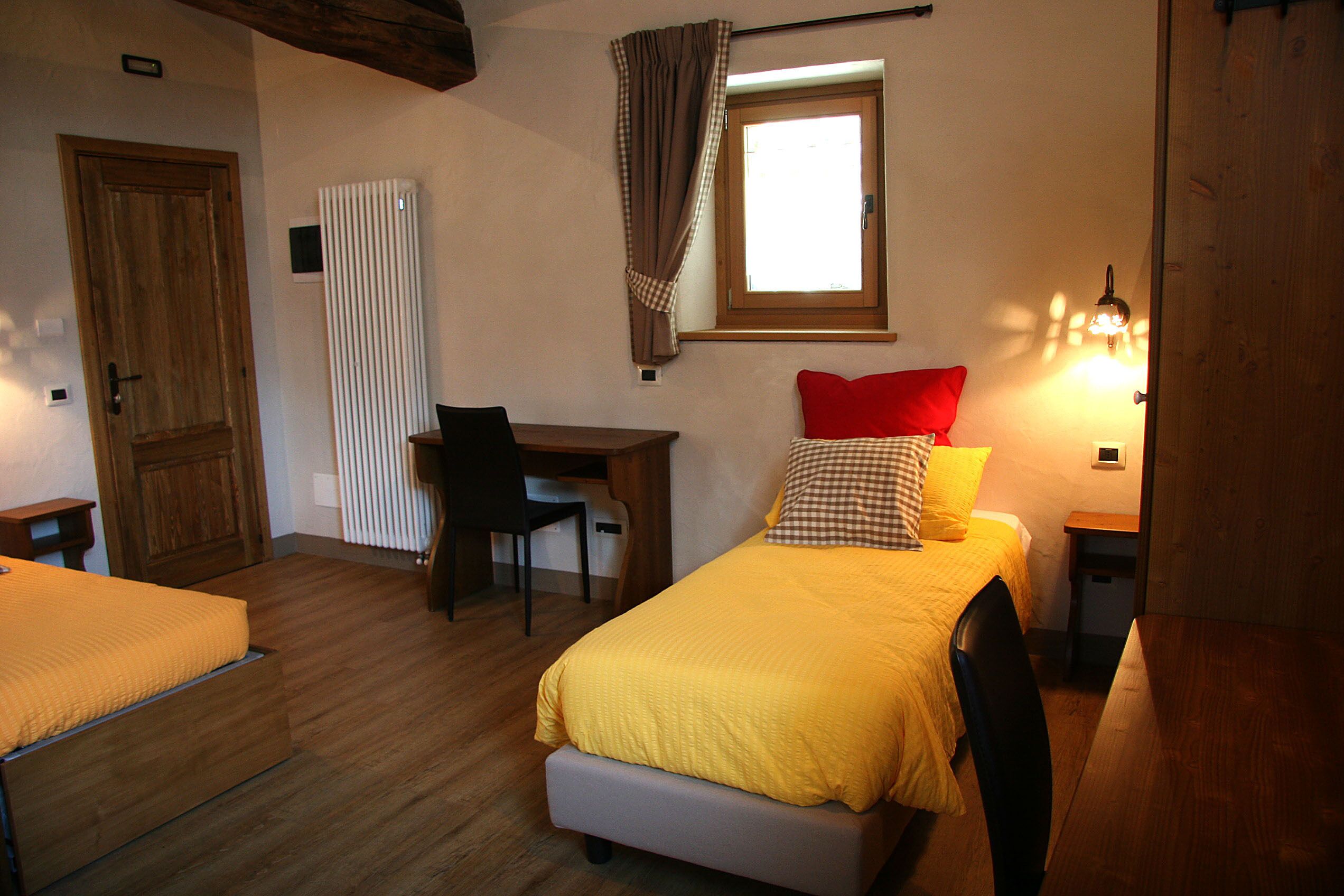 Un dormitorio con cama, escritorio y silla.