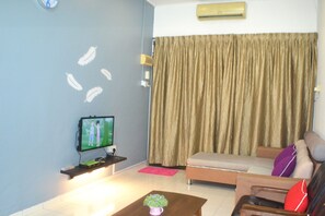 A living room with a flat-screen TV, a sofa, a coffee table, and a curtain. - Sakura Homestay Kampar (Kampar)