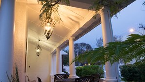 A covered porch with a table and chairs, columns, and a hanging light fixture. - 5 Camp Street Guesthouse & Self-catering (Cape Town)