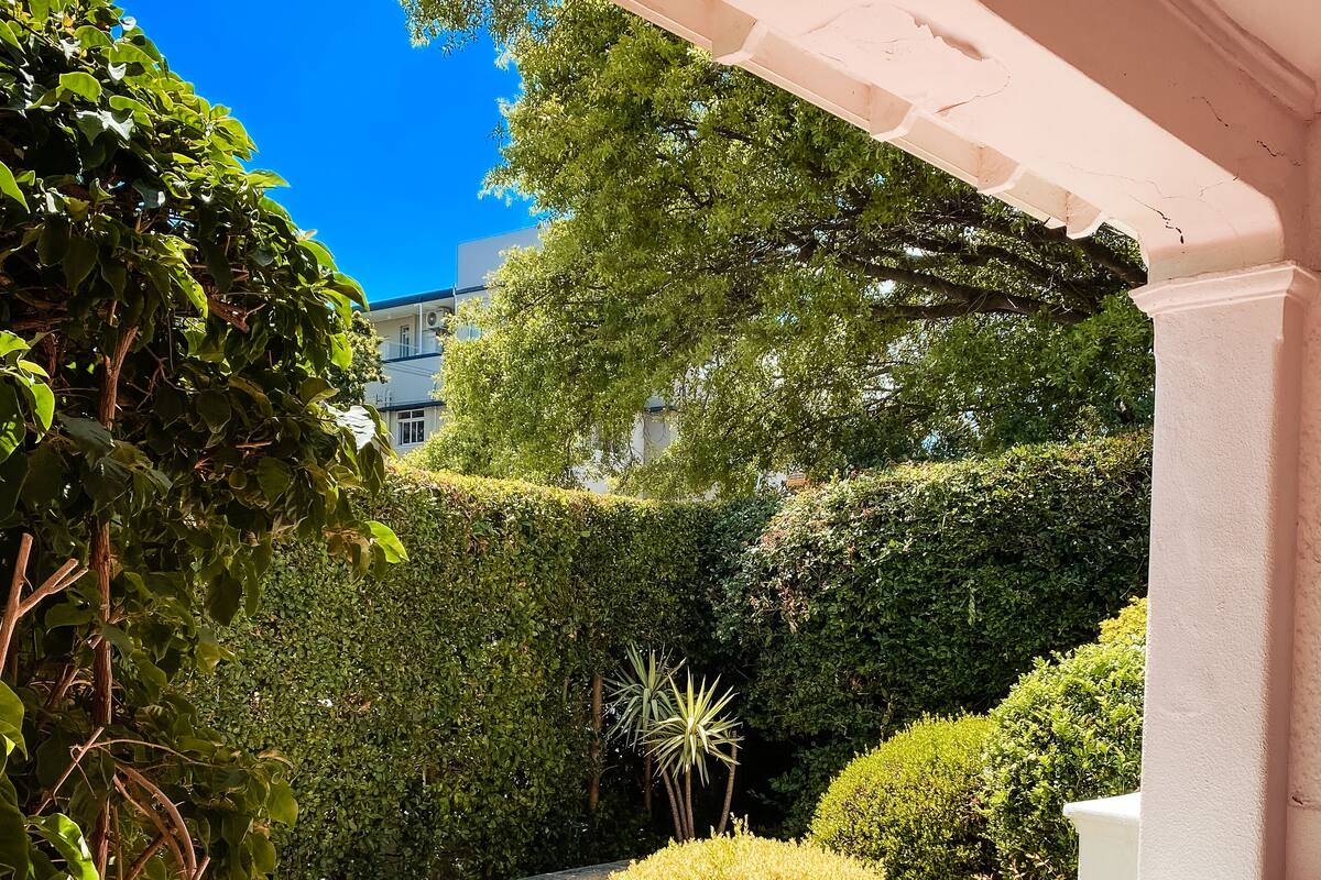 A well-maintained garden with various shrubs and a clear blue sky.