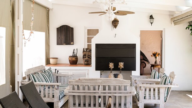 A spacious patio with wooden furniture, a ceiling fan, and a flat-screen TV mounted on the wall. - 5 Camp Street Guesthouse & Self-catering (Cape Town)