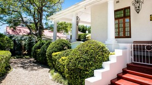A building with a covered porch, white columns, and a staircase leading to the entrance. - 5 Camp Street Guesthouse & Self-catering (Cape Town)