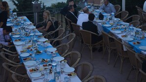 An outdoor dining area with tables set for a meal, overlooking a river with bridges and a cityscape in the background. - Turquhouse Boutique Hotel (Eyup)