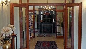 A reception area with a wooden door, a chandelier, a fireplace, and a rug. - Turquhouse Boutique Hotel (Eyup)