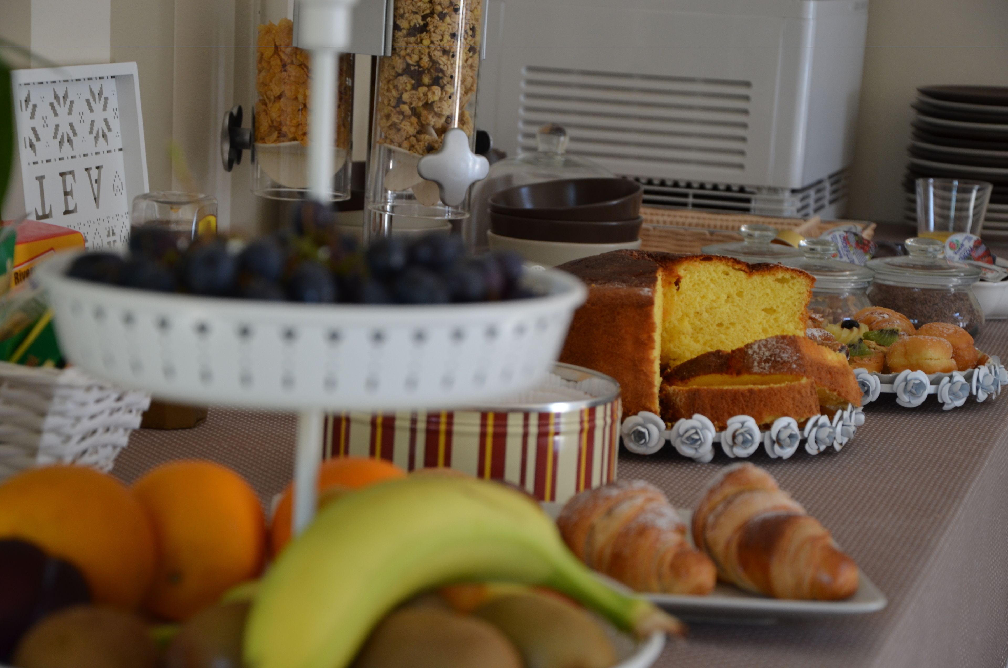 Un bufé de desayuno con diversas opciones de comida, entre ellas frutas, pasteles y un pastel.