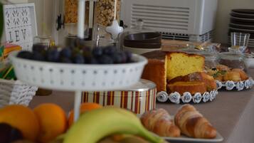 Un bufé de desayuno con diversas opciones de comida, entre ellas frutas, pasteles y un pastel.