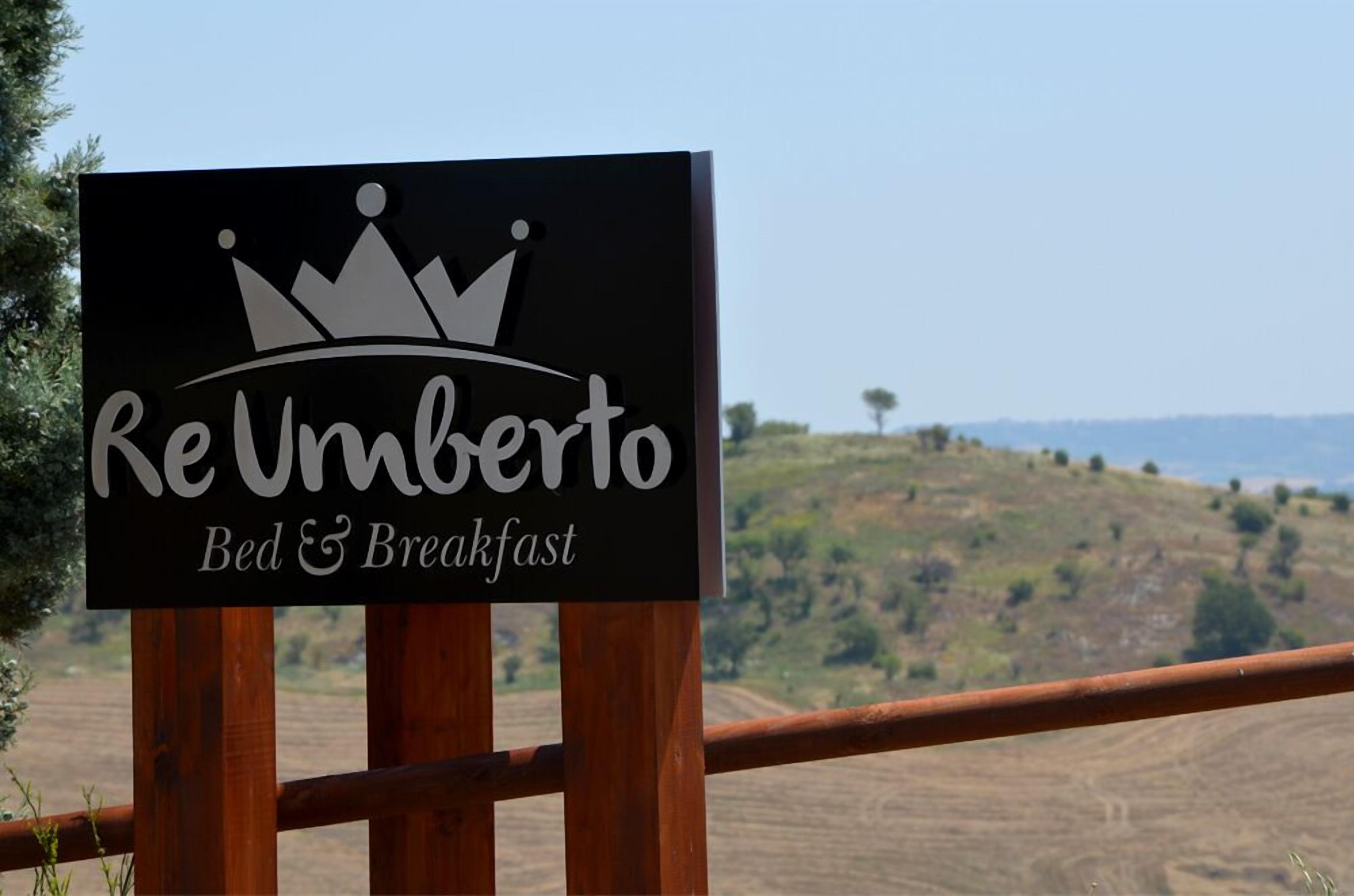 Schild für Re Umberto Bed & Breakfast mit einem Kronenlogo und einer malerischen Aussicht im Hintergrund.