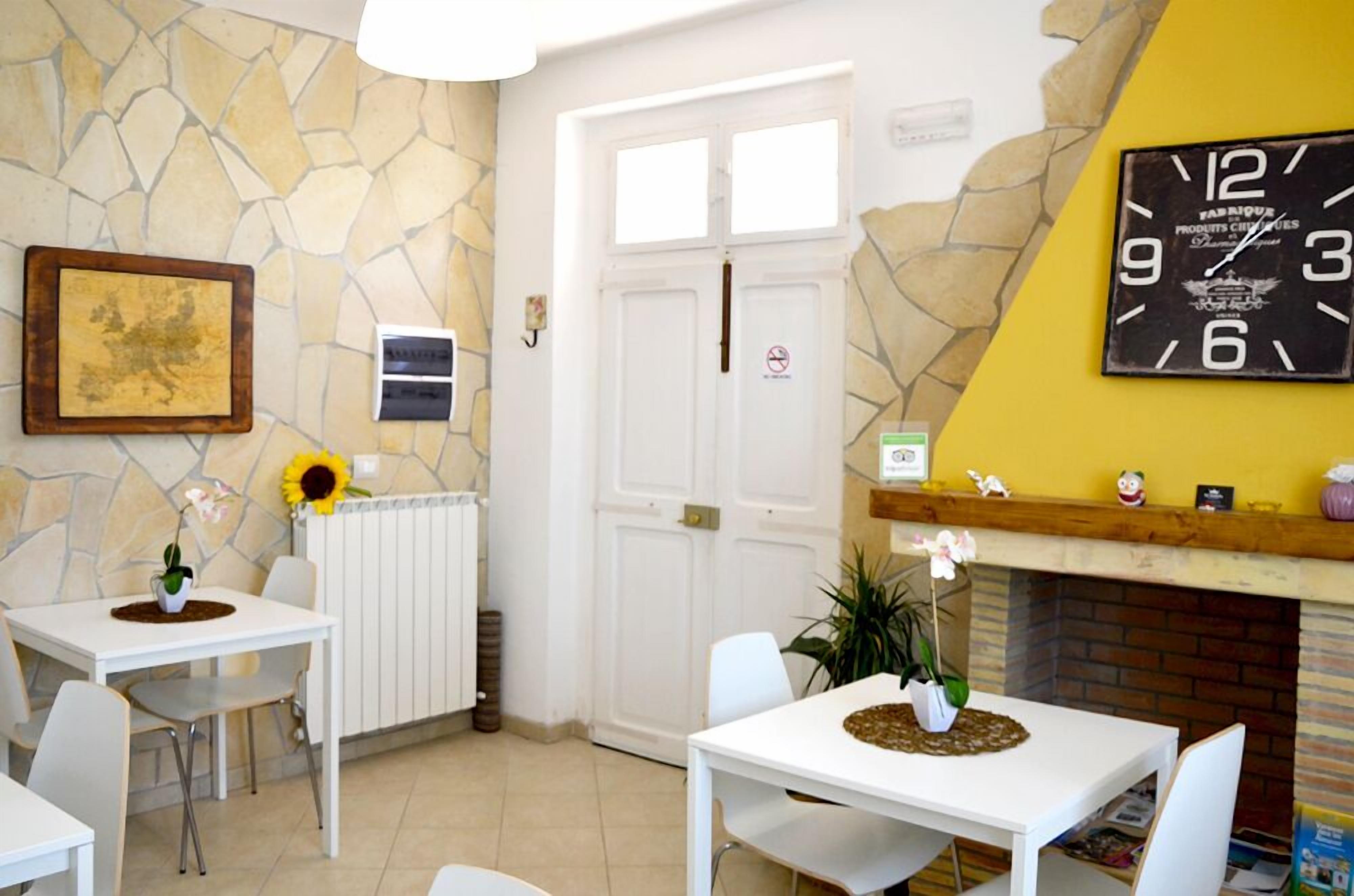 A room with a stone wall, a white door, a clock, and a fireplace.