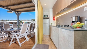 A modern kitchen with a built-in microwave, a coffee maker, and a fruit bowl on the counter.