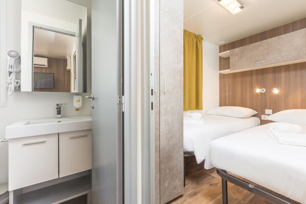 Una habitación de hotel con baño, cama y espejo.