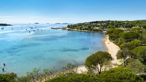 A coastal area with clear blue waters, boats, and a sandy beach.