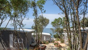 A row of mobile homes with a pathway leading to a beach.