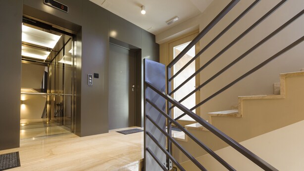 A modern interior with a marble staircase, a glass elevator, and a metal railing. - Residence by Vestibul Palace (Split)