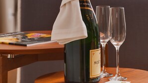 A bottle of Moët champagne with a white napkin, two empty glasses, and a magazine on a wooden table in a hotel room. - Residence by Vestibul Palace (Split)