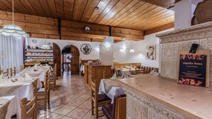 Un restaurant avec des tables et des chaises en bois, un coin bar et des éléments décoratifs sur les murs.