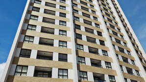 Un hotel alto y moderno con múltiples pisos, ventanas amplias y techo plano.