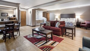 A modern living room with a dining area, a sofa set, a coffee table, and a fireplace. - Red Roof Inn & Suites Jacksonville, NC (Jacksonville)