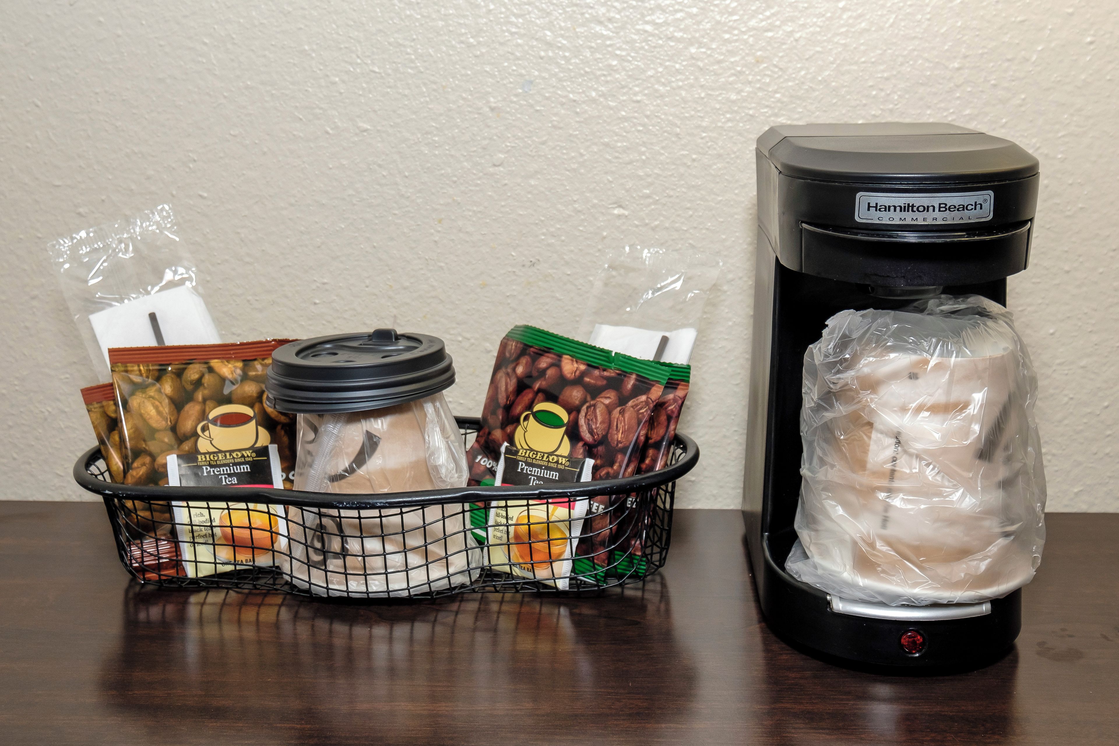 A coffee maker and a basket with various coffee pods and a bag of coffee beans.
