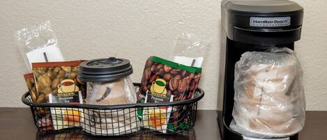 A coffee maker and a basket with various coffee pods and a bag of coffee beans.
