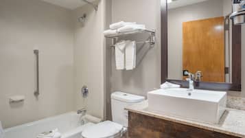 A modern bathroom with a bathtub, toilet, and sink.