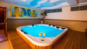 A hot tub with a wooden floor and a ceiling with recessed lighting.