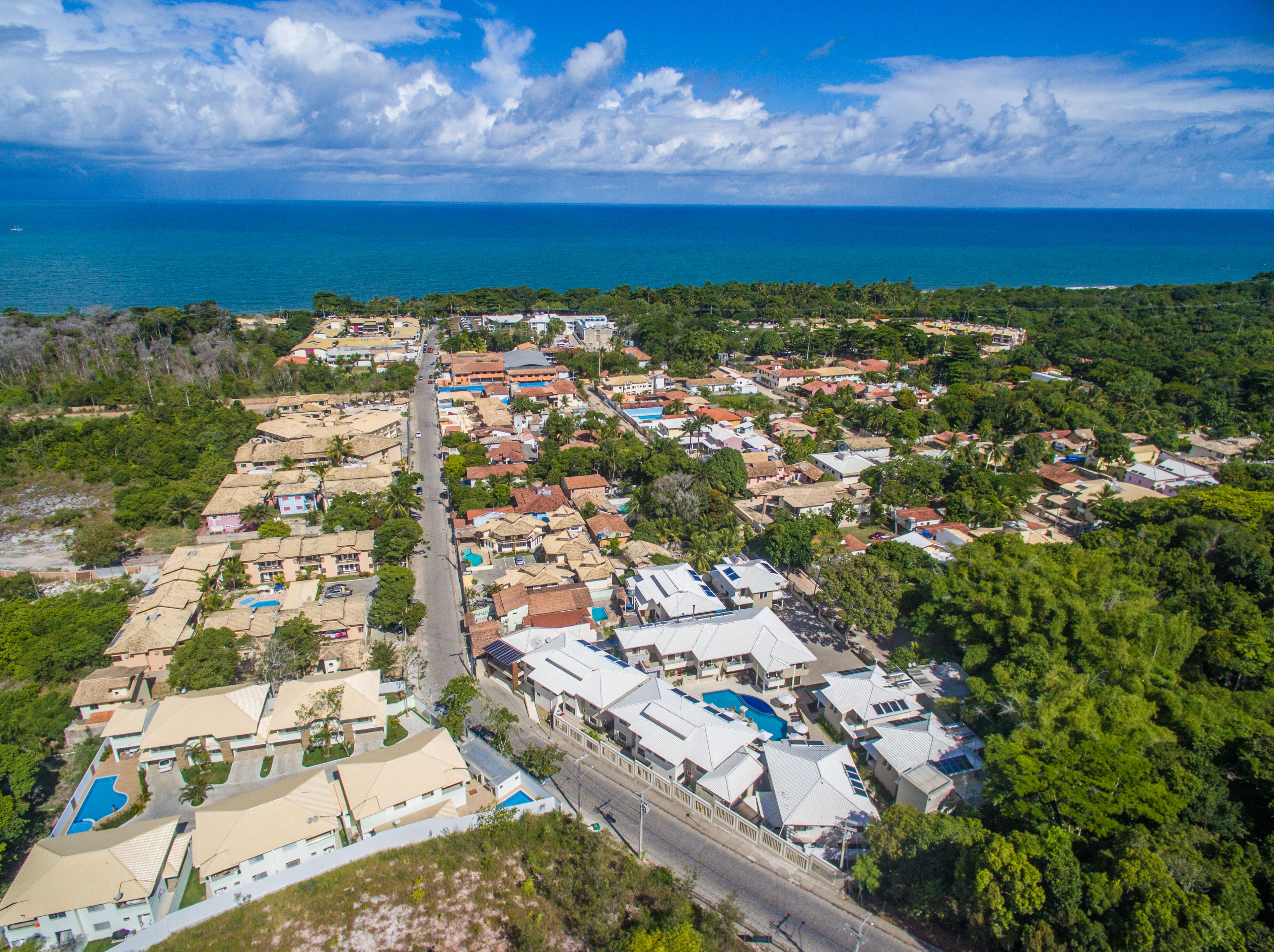 Vista aèria d'una zona residencial costanera amb cases, carreteres i una platja.
