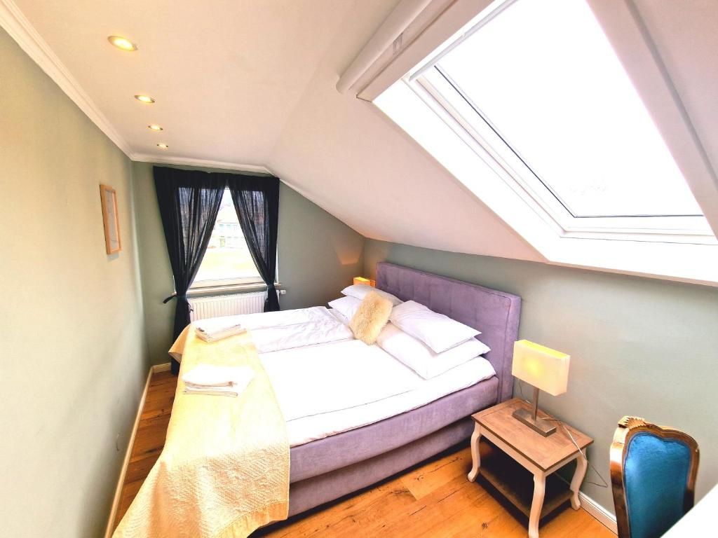 Une chambre à coucher avec un lit, une table de chevet, une lampe et un puits de lumière.