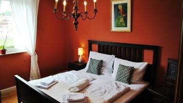 Een hotelkamer met een bed, een nachtkastje, een lamp en een schilderij aan de muur.