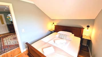 Ein Schlafzimmer mit einem hölzernen Bett, zwei Nachttischlampen und einem Nachttisch.