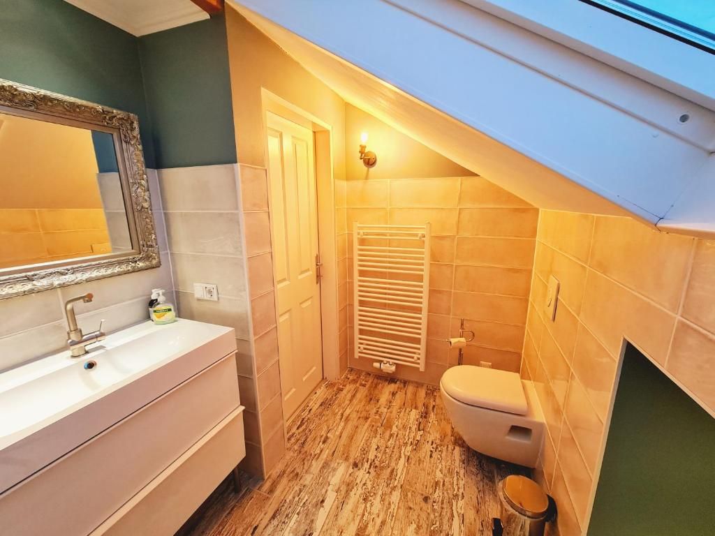 A small bathroom with a vanity, a toilet, and a towel rack.