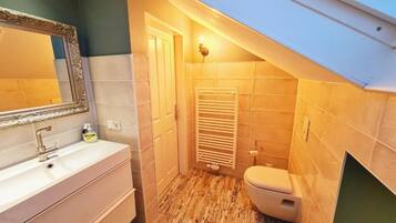 A small bathroom with a vanity, a toilet, and a towel rack.